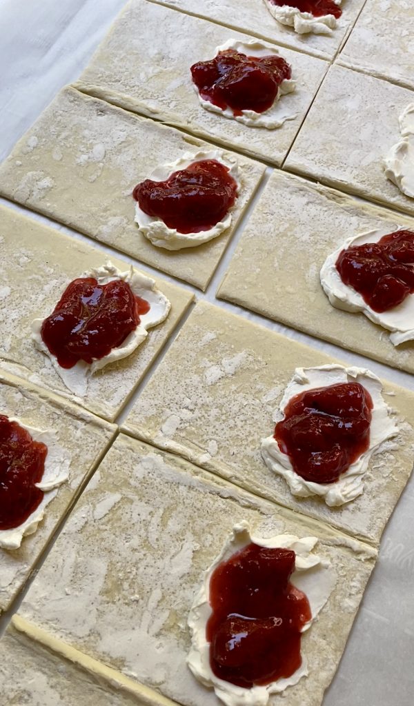 pastries being filled to get ready for baking.