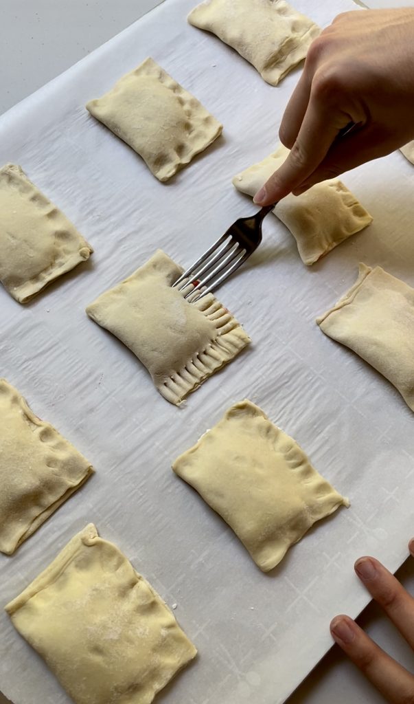 edges of puff pastry are sealed with the prongs of a fork.