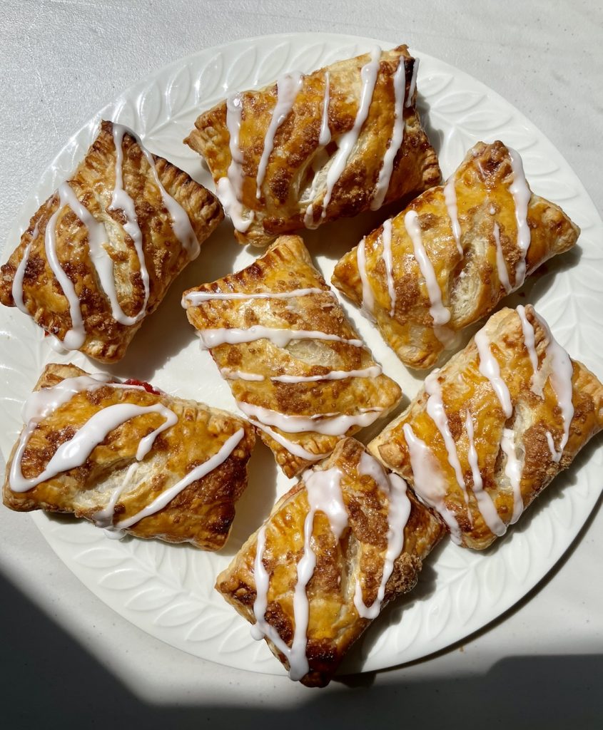 golden and flakey strawberry turnovers with a vanilla glaze.
