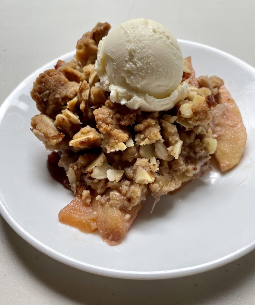 apple strawberry crisp with a big scoop of vanilla ice cream.