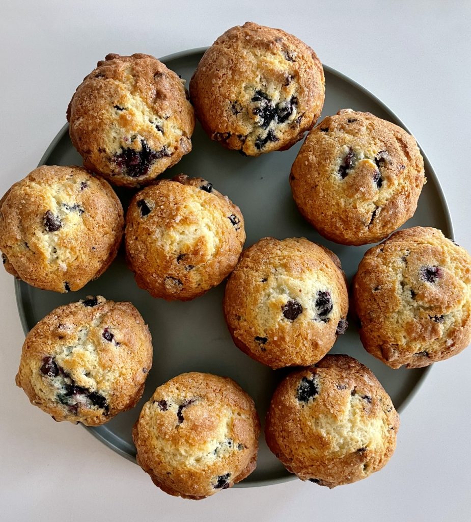 Baked blueberry chocolate chip muffins on a plate.