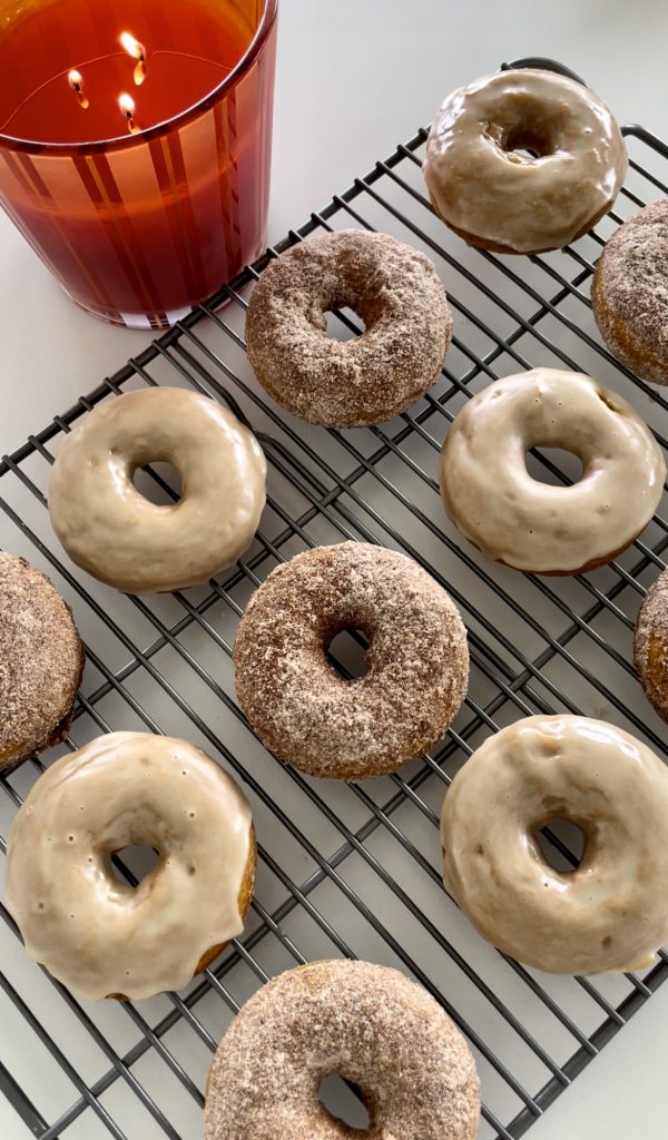 Baked pumpkin spice donuts. Half coated in cinnamon sugar and half dipped in maple glaze.