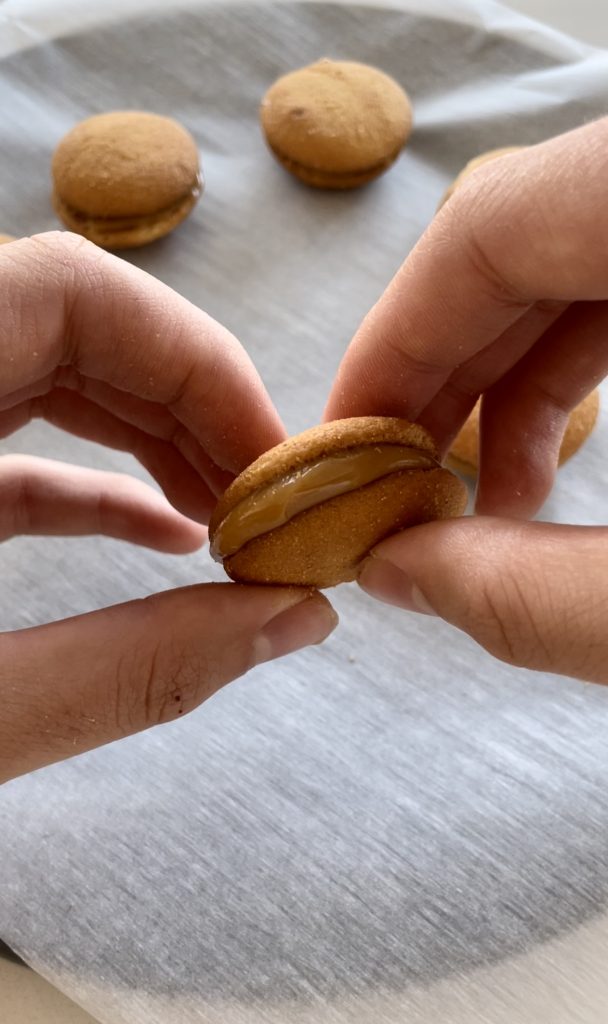 Assembling the Nilla Wafer and dulce de leche sandwich cookies to coat in chocolate.