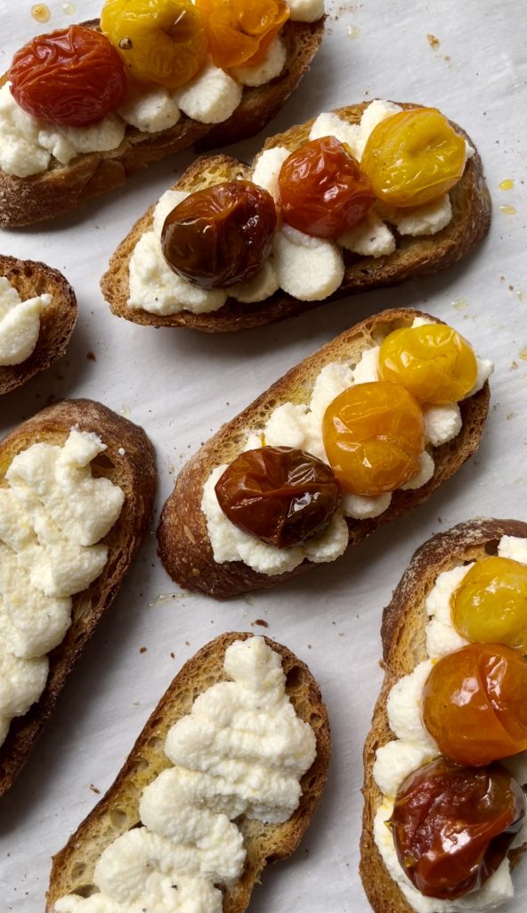 When adding the tomatoes to the whipped ricotta crostini, spoon on some of the extra juices from the baking dish as well. 